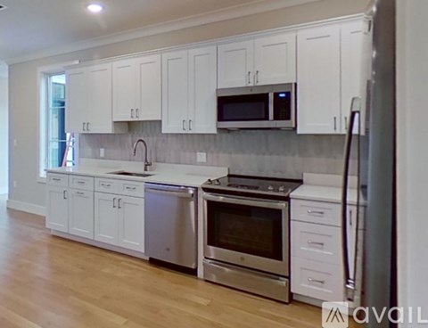 A kitchen with white cabinets and stainless steel appliances.