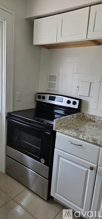 A kitchen with a black stove top oven and a white drawer.