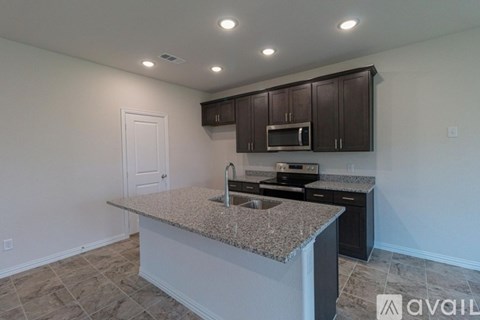 A kitchen with granite countertops and dark brown cabinets.