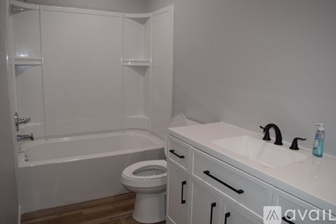 A white bathroom with a toilet, sink, and bathtub.