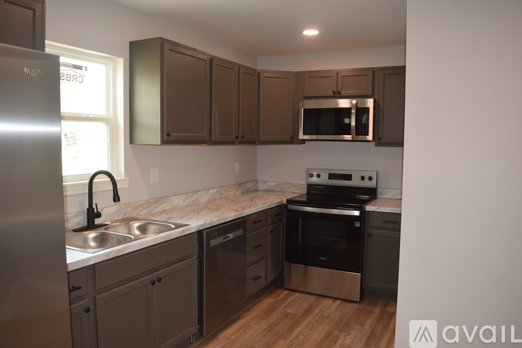 A kitchen with a stainless steel refrigerator, sink, and oven.