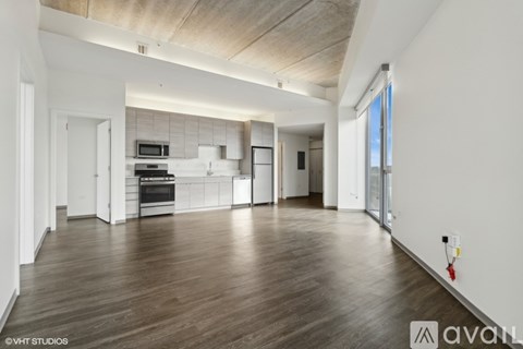 A spacious kitchen with wooden floors and white walls.