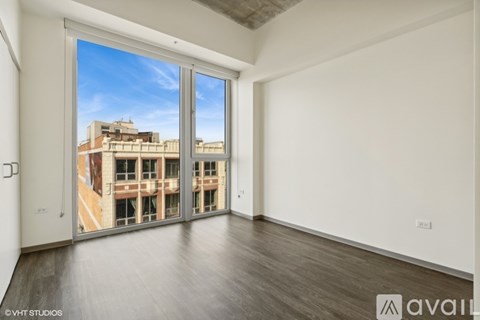 A room with a view of a building outside through the window.