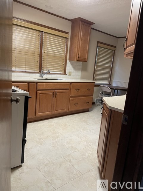 A kitchen with wooden cabinets and a black refrigerator.