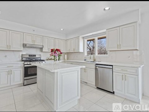A kitchen with white cabinets and appliances.