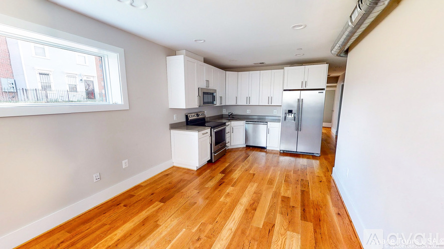 A kitchen with wooden floors and white appliances.