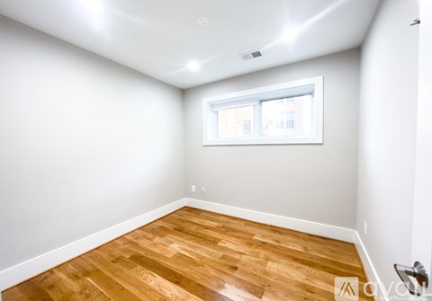 A room with wooden flooring and a window.