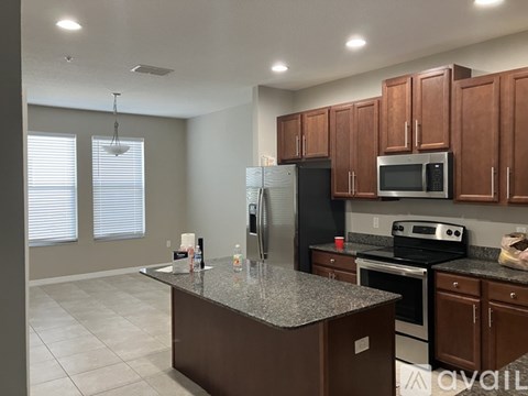 A kitchen with brown cabinets and a granite countertop.