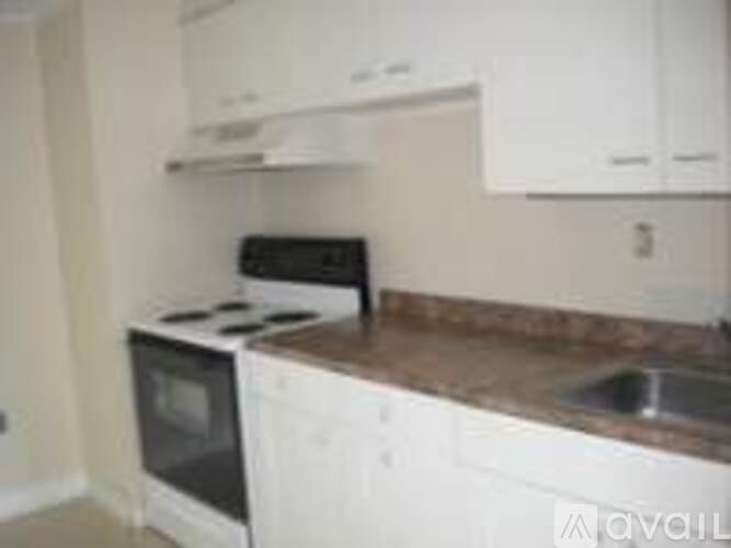 A kitchen with white cabinets and a granite counter top.