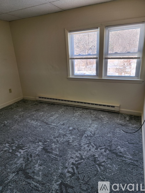 A room with a carpeted floor and a window.
