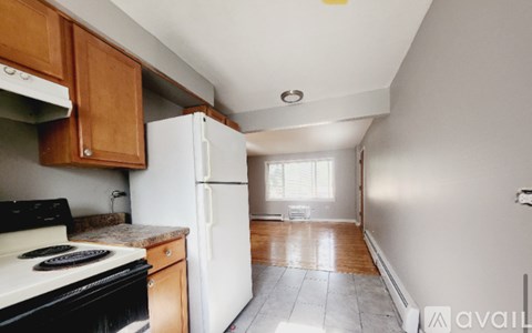 A kitchen with a black stove top oven and a white refrigerator.