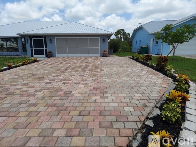 A driveway with a brick pattern leading to a garage.