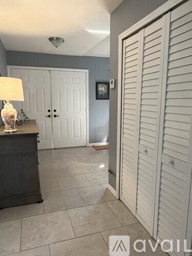 A room with a white door and a grey wall.