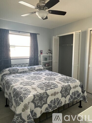 A bedroom with a bed covered in a patterned bedspread.
