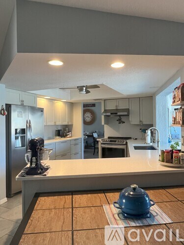 A kitchen with a wooden table and a blue pot on it.