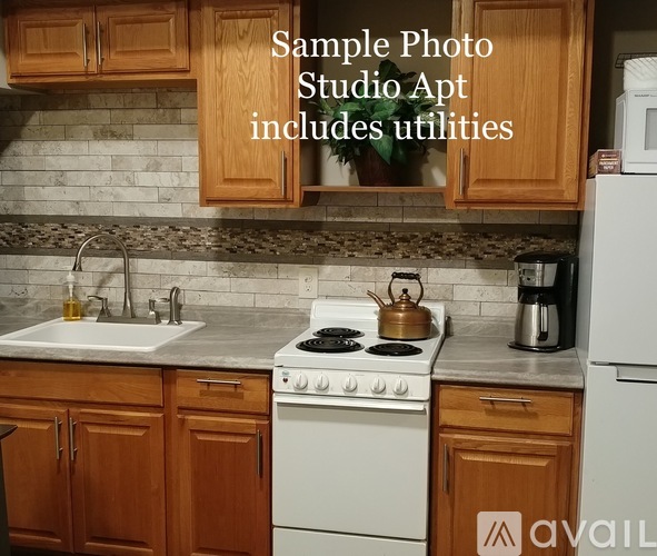 A black sink is installed in a kitchen with wooden cabinets.