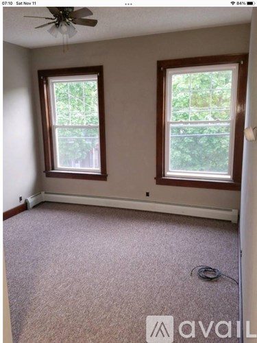 A room with two windows and a ceiling fan.
