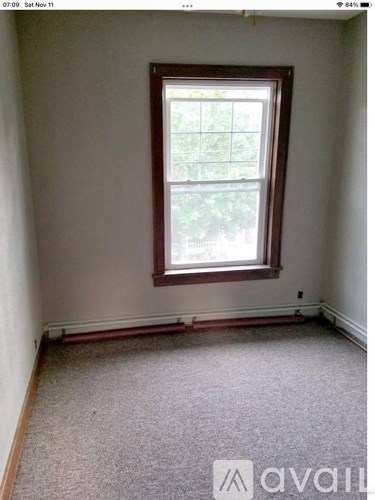 A room with a window and carpeted floor.