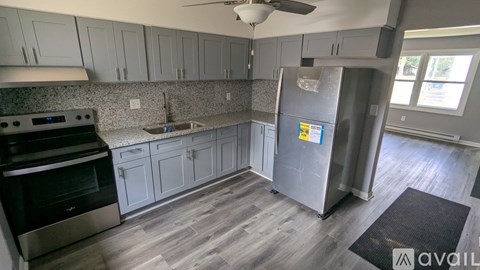 A kitchen with a refrigerator, sink, and stove.