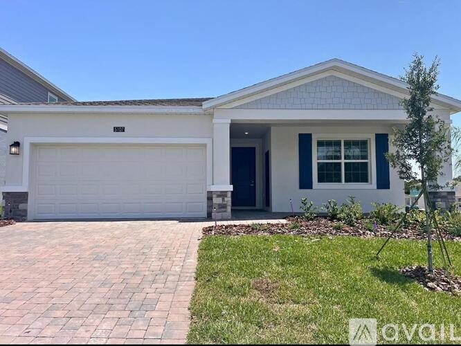 A house with a white garage door and a blue window.