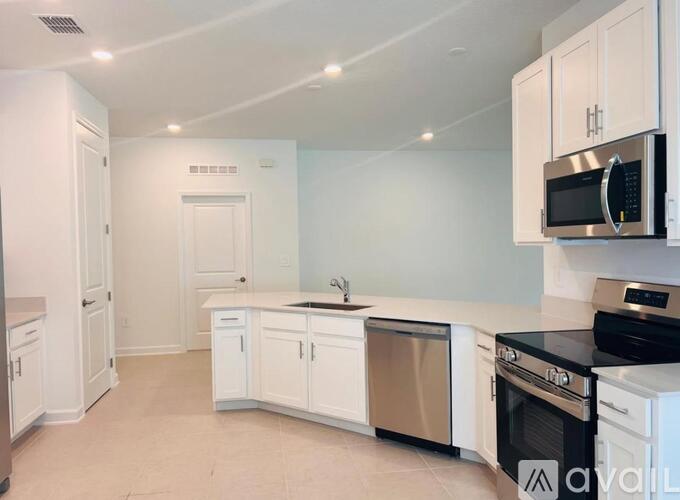 A kitchen with white cabinets and appliances.