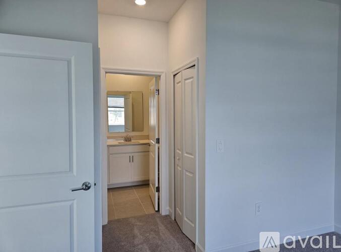 A white door is open to a small bathroom.