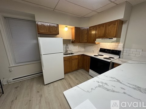 A kitchen with a white fridge and black stove top.