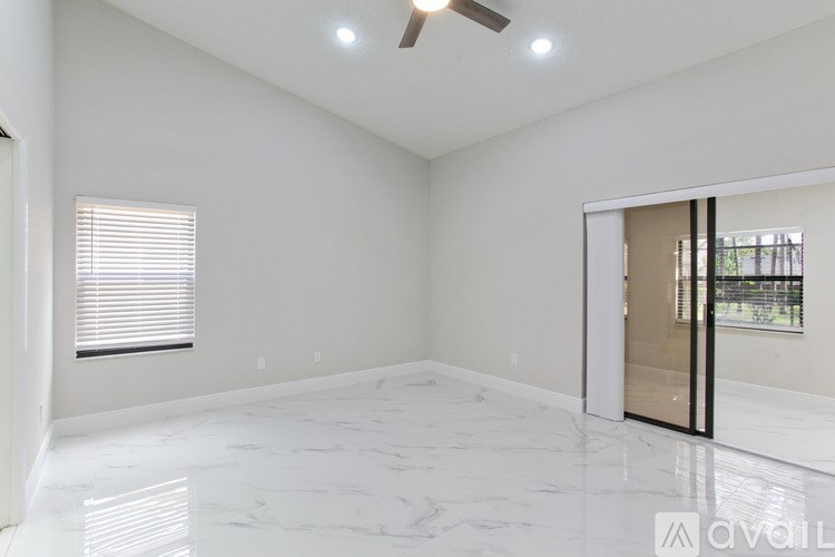 A room with a tiled floor and a window with blinds.