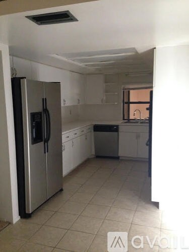 A kitchen with a refrigerator, dishwasher, and oven.