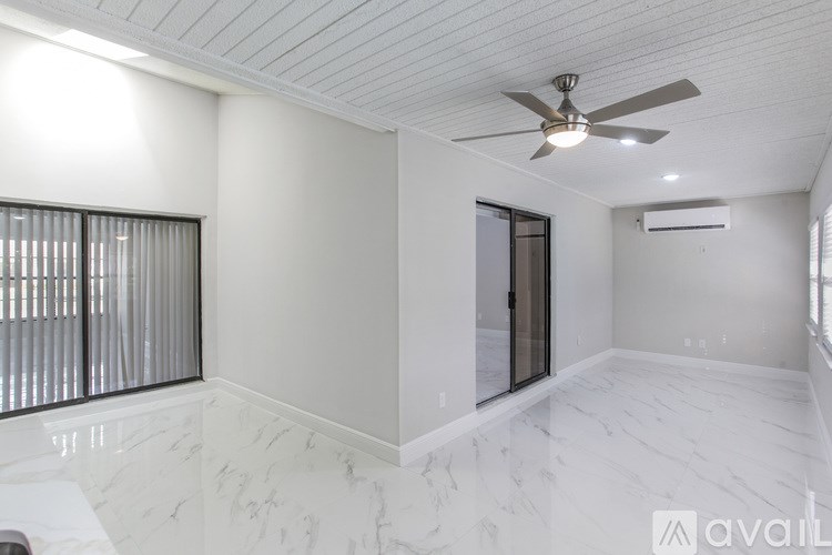 A spacious room with a ceiling fan and a marble floor.