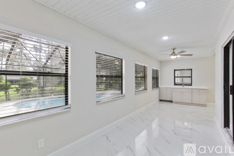 A spacious room with a pool visible through the window.