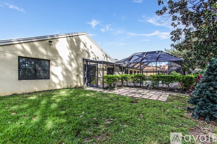 A house with a patio and a tree in front.