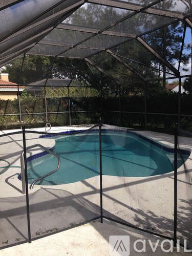 A pool enclosed by a black fence with a mesh top.