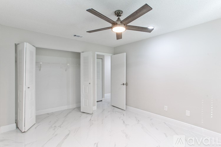 A room with a ceiling fan and tile floor.