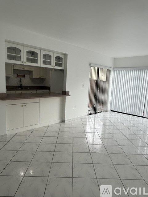 A kitchen with white cabinets and a tiled floor.