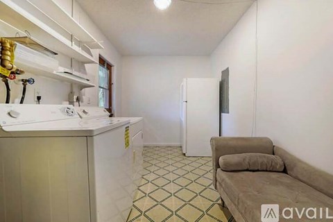 A kitchen with a white counter and a couch in the living room.