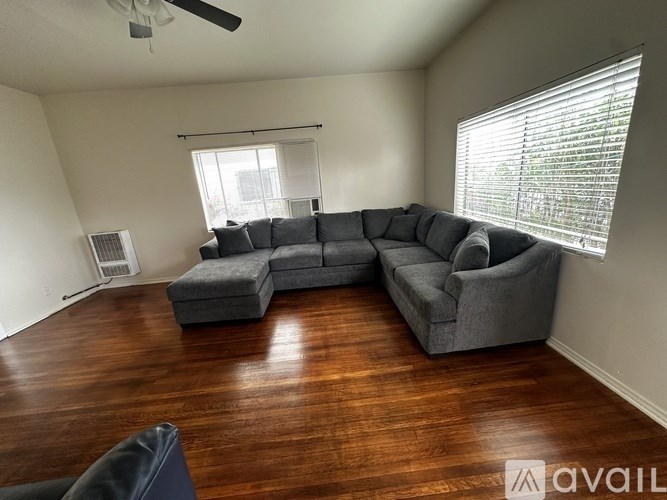 A living room with a grey sectional sofa and a black chair.