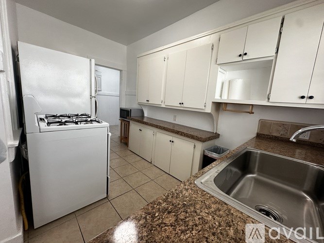 A kitchen with white appliances and cabinets.