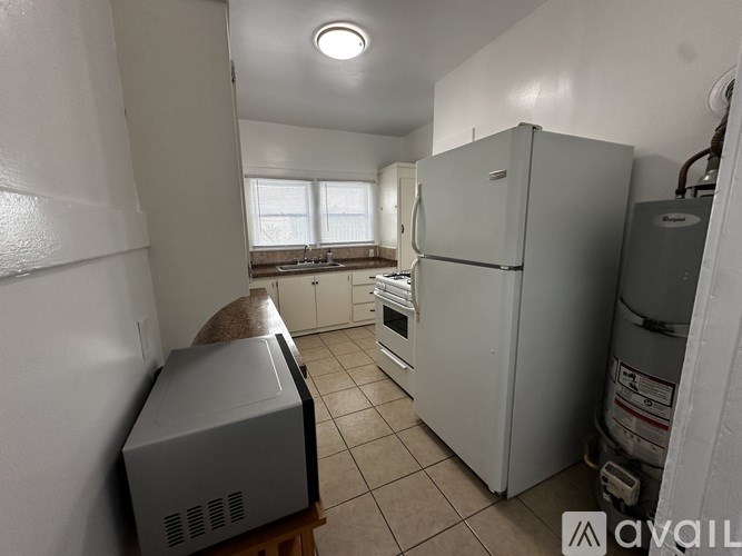 A kitchen with a white fridge, a white microwave, and a white oven.