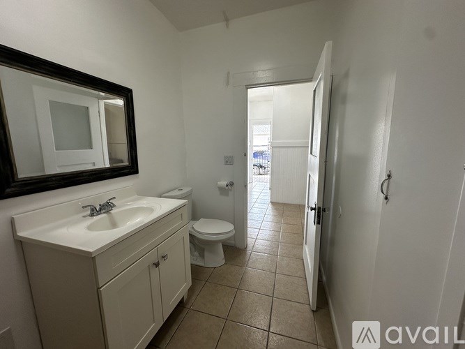 A bathroom with a sink, mirror, and toilet.
