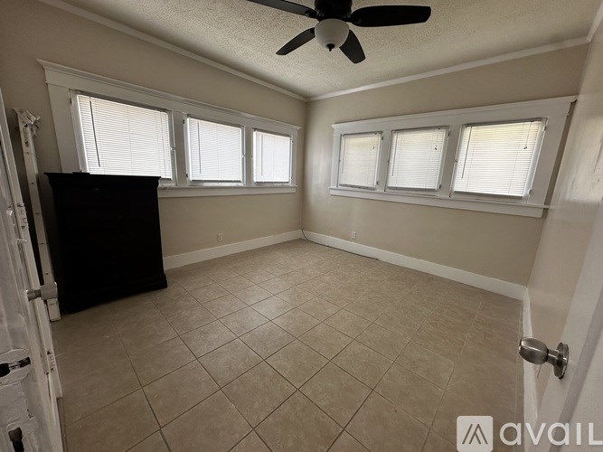 A room with a ceiling fan and tiled flooring.