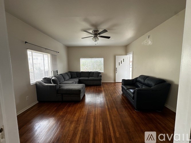 A living room with a ceiling fan and two couches.