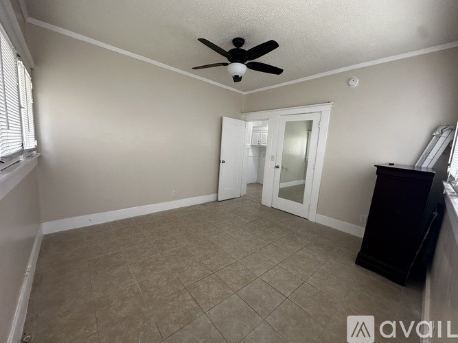 A room with a ceiling fan and tile flooring.