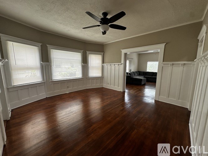 A room with wooden floors and a ceiling fan.