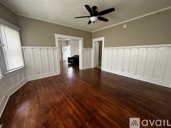 A room with wooden floors and a ceiling fan.