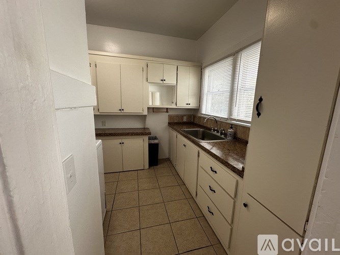A kitchen with white cabinets and a countertop.