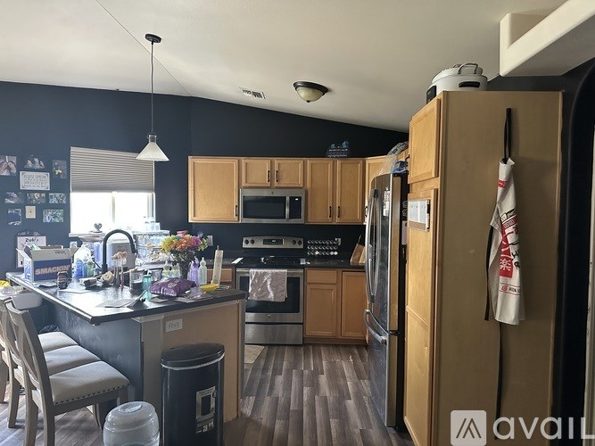 A kitchen with wooden cabinets and a black fridge.