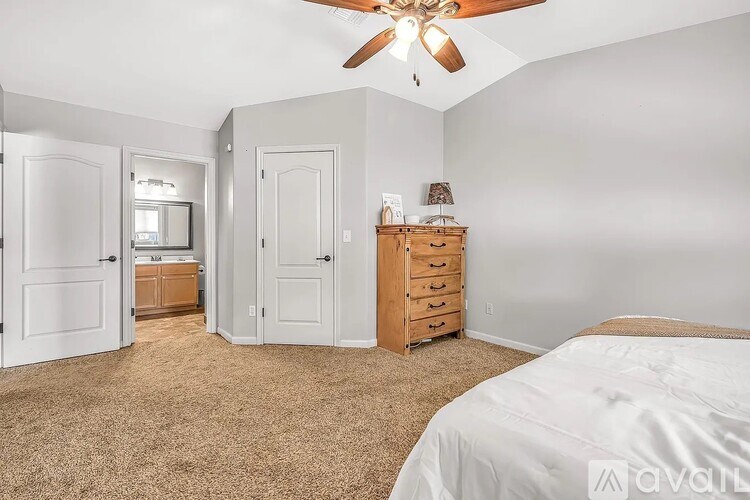 A bedroom with a bed, dresser, and mirror.