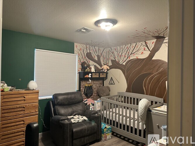 A baby room with a mural of a deer on the wall.