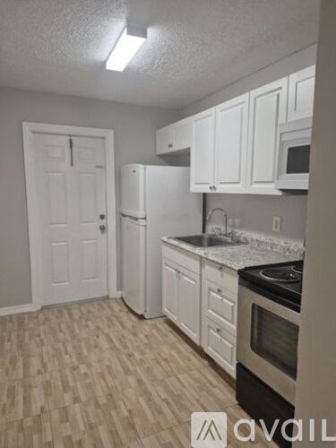 A kitchen with white cabinets and a black stove top oven.